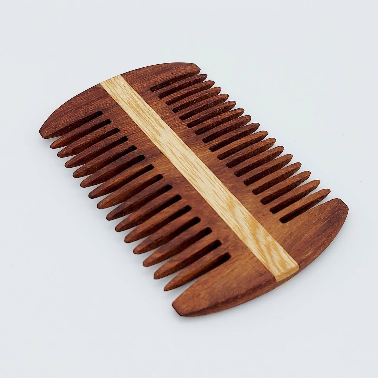 A wooden beard comb with dark brown teeth and a light natural wood center stripe, shown on a light gray background.