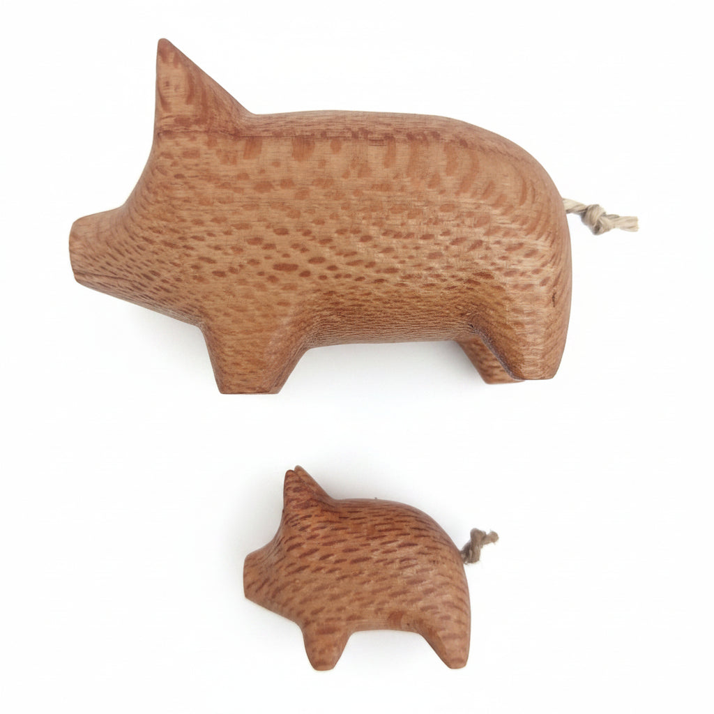 Two wooden pig figurines on a white background